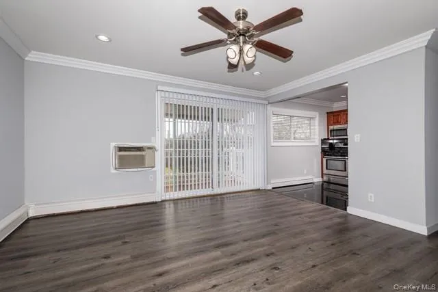 a view of an empty room with a window and wooden floor