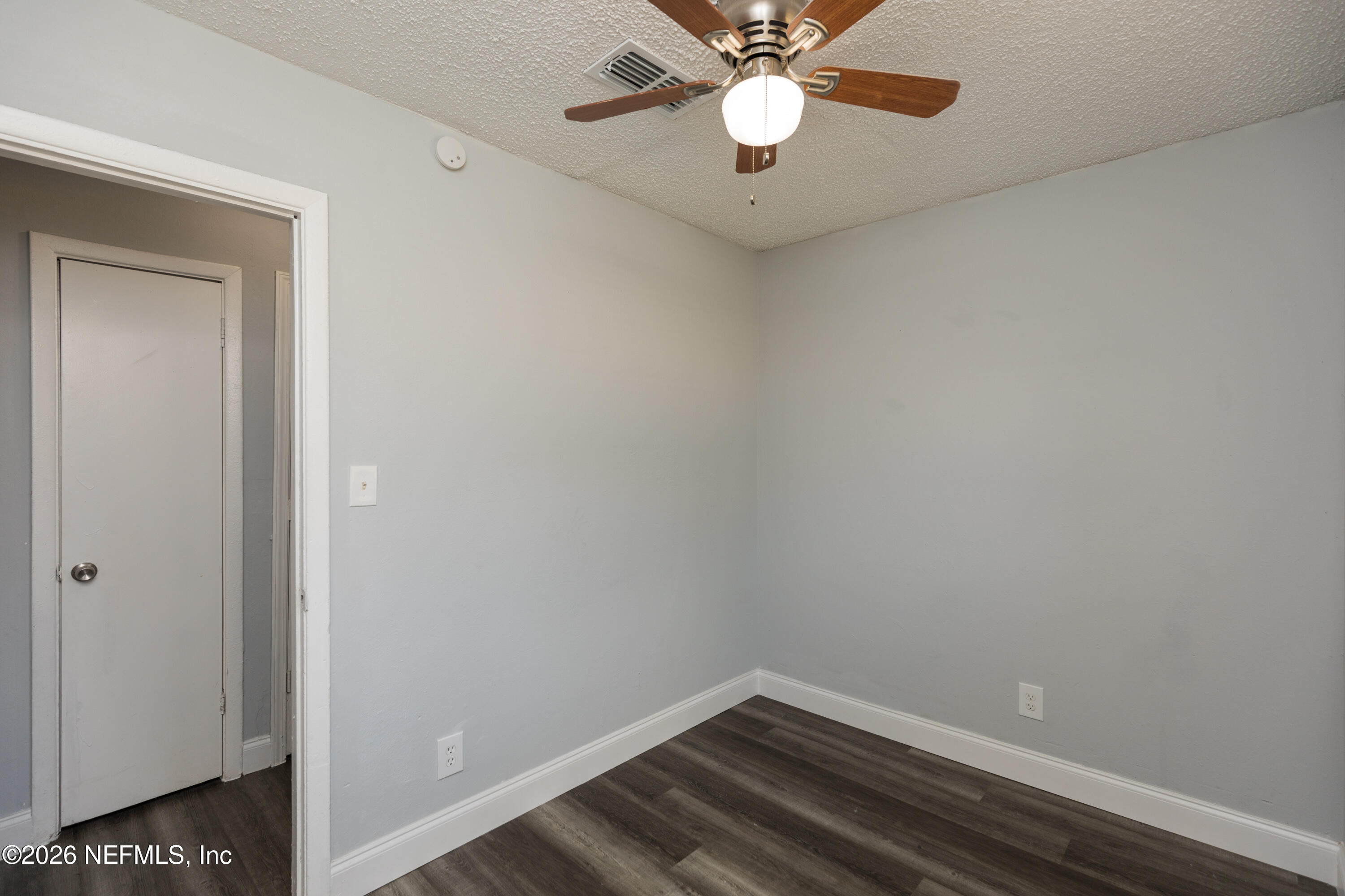 2255 West 13th Street Jacksonville, FL 32209 - Photo 17 of 29 an empty room with a chandelier fan and wooden floor