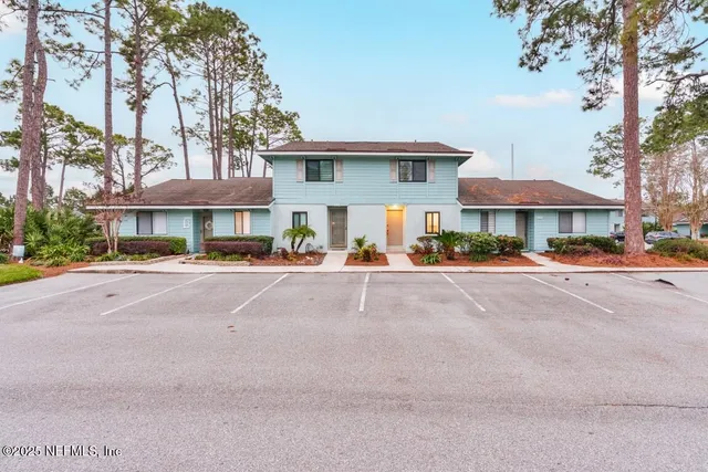 a view of a house with potted plants and a bench