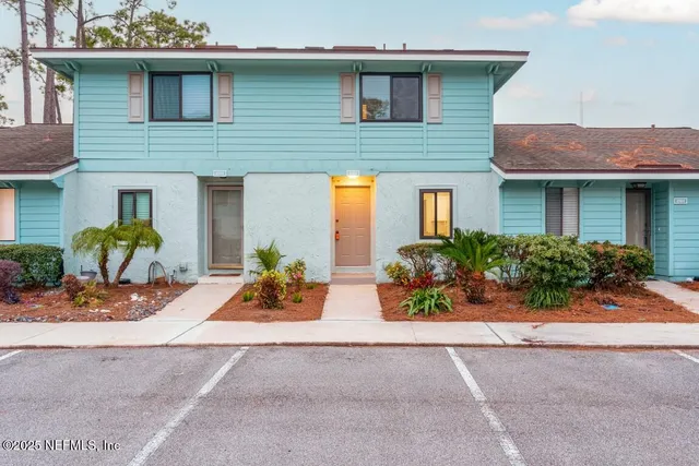 a view of an empty room with wooden floor and a fireplace