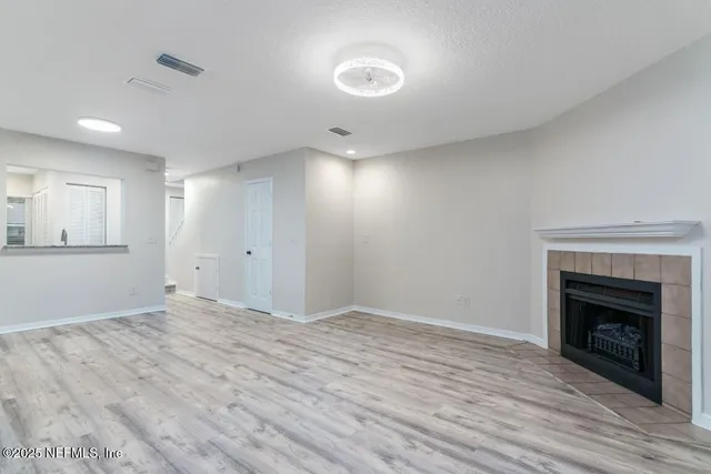 a kitchen with granite countertop white cabinets and a stove with wooden floor