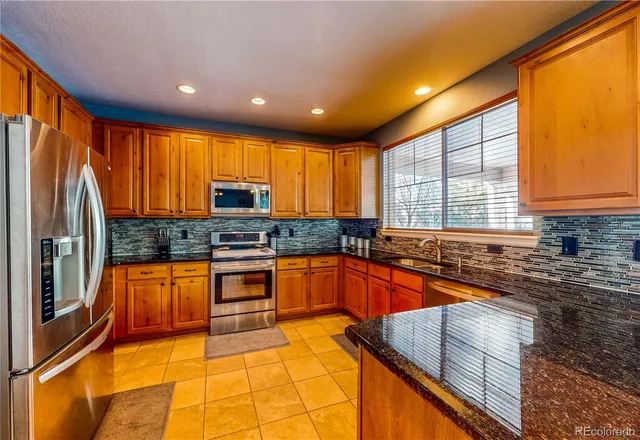 a kitchen with granite countertop sink stove and cabinets