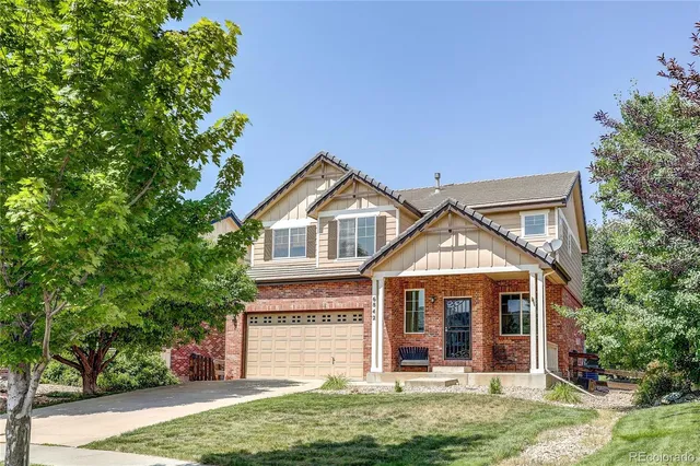 a view of a house with a yard and potted plants