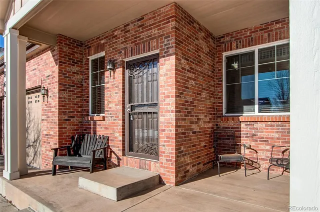 a view of a patio with lawn chairs next to a yard
