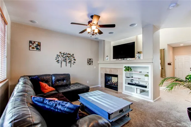 a living room with furniture a flat screen tv and a fireplace