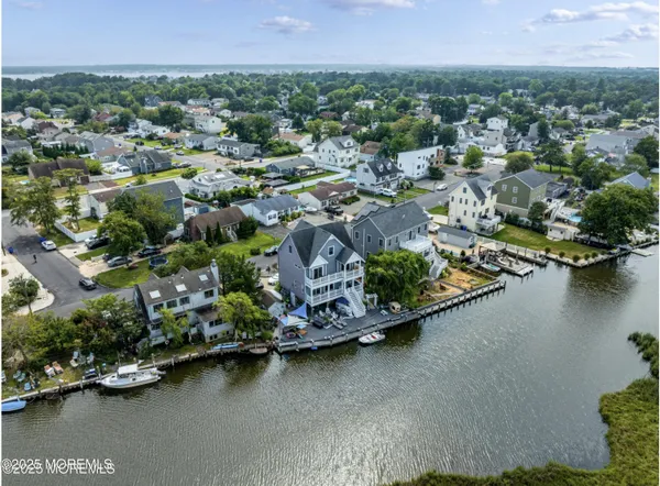 an aerial view of residential houses with outdoor space and lake view