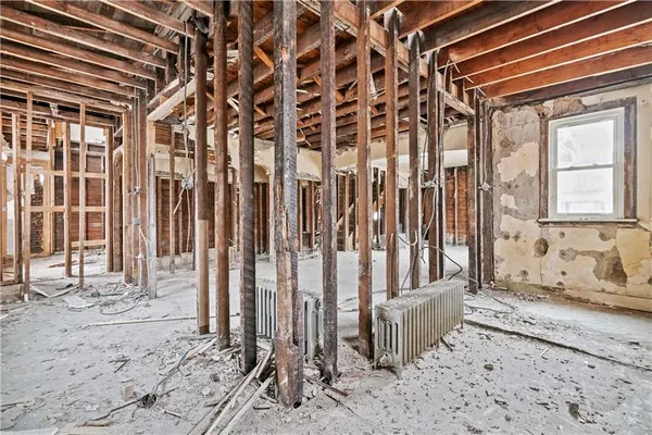 a view of an empty room with wooden roof and windows