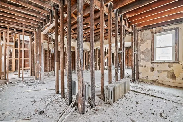 a view of an empty room with wooden roof and windows