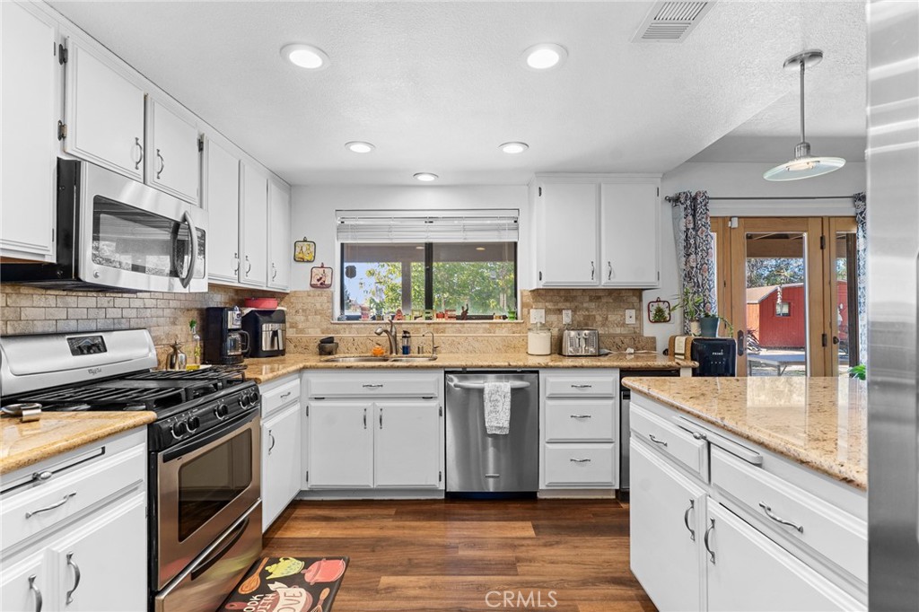 20071 Serrano Road Apple Valley, CA 92307 - Photo 18 of 38 a kitchen with stainless steel appliances granite countertop a stove sink and cabinets