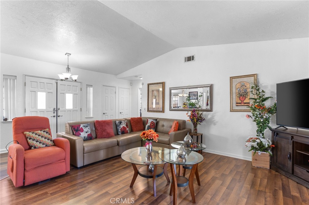 20071 Serrano Road Apple Valley, CA 92307 - Photo 9 of 38 a living room with furniture a wooden floor and a chandelier