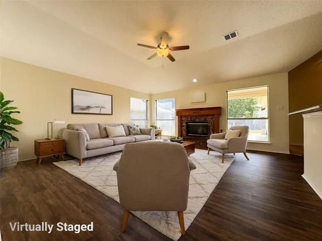 a living room with furniture fireplace and a large window