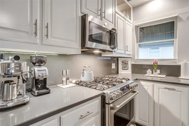 a kitchen with stainless steel appliances granite countertop a sink stove and cabinets
