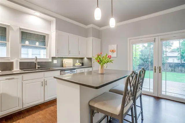 a kitchen with a table chairs and white cabinets