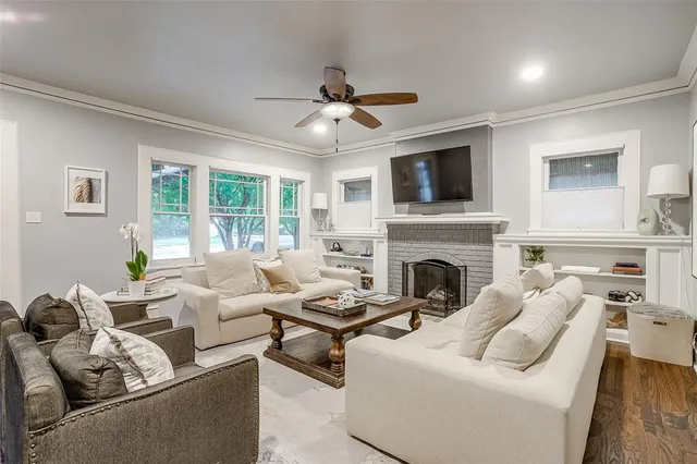 a living room with furniture fireplace and a large window