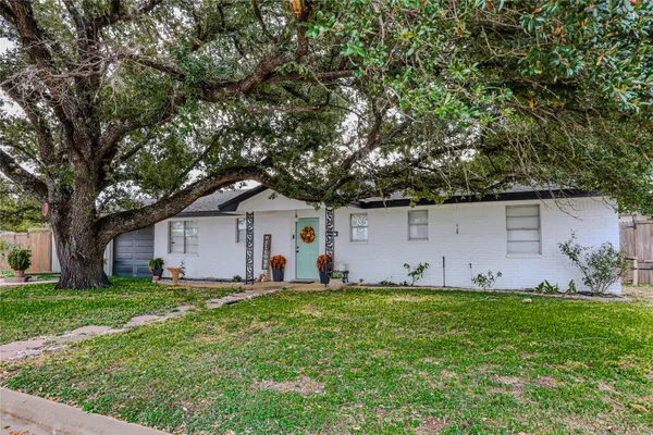 a house view with a garden and trees