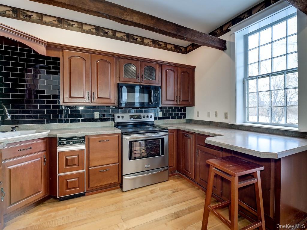 6 Bart Bull Road Middletown, NY 10941 - Photo 13 of 24 Kitchen featuring stainless steel range with electric cooktop, light wood finished floors, black microwave, a peninsula, and light countertops