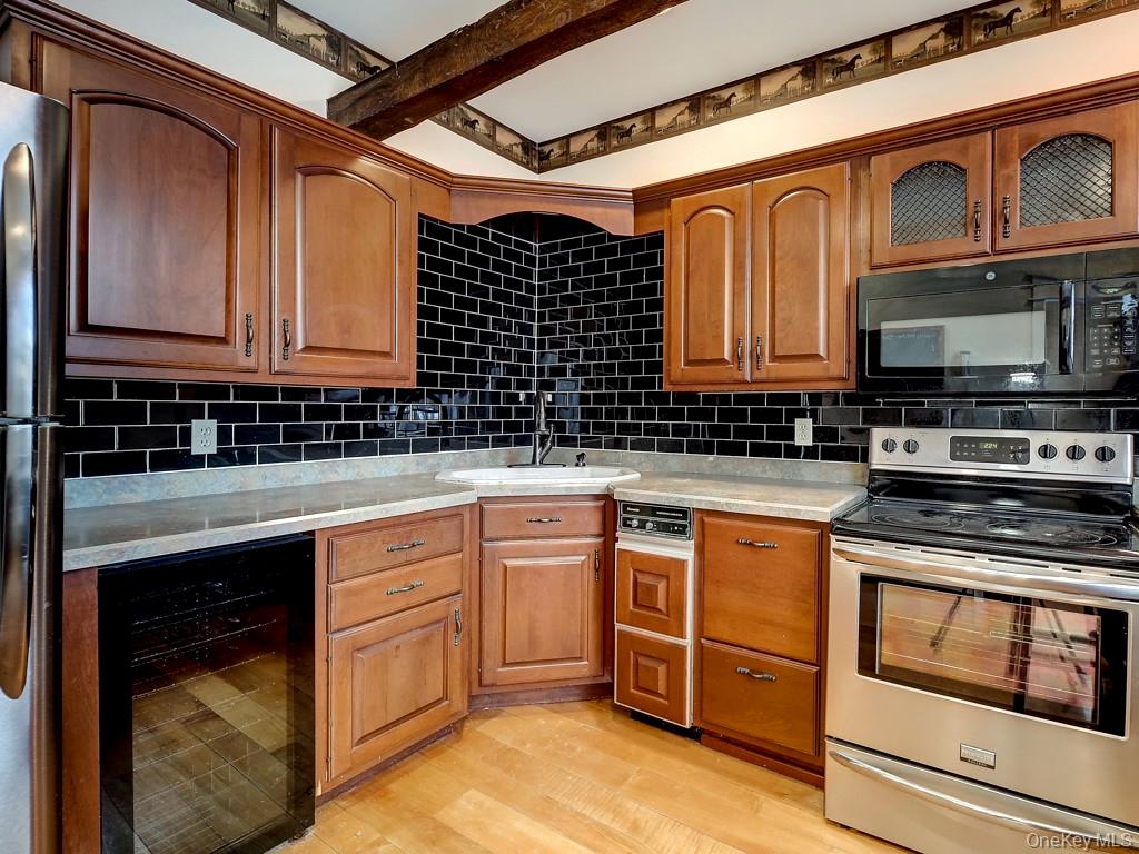 6 Bart Bull Road Middletown, NY 10941 - Photo 14 of 24 Kitchen with stainless steel appliances, beverage cooler, tasteful backsplash, and brown cabinetry