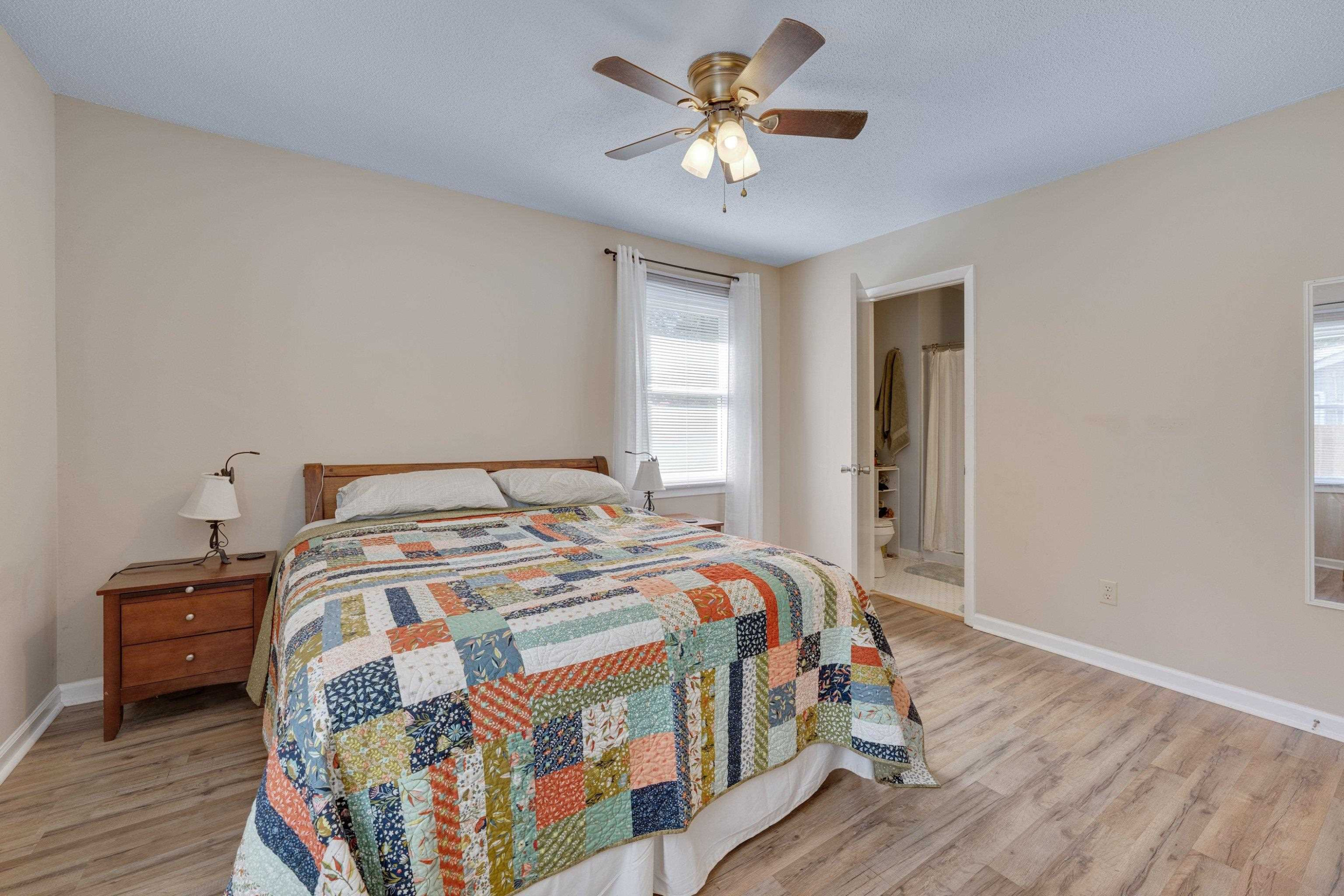 704 Wheat Mill Road Durham, NC 27704 - Photo 18 of 23 a bedroom with a bed and a chandelier