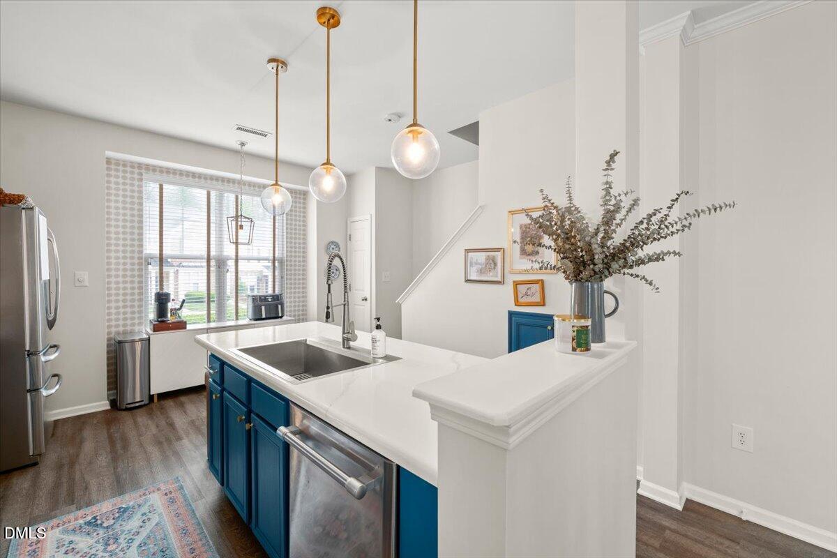 8449 Central Drive Raleigh, NC 27613 - Photo 16 of 38 a kitchen with a sink and dishwasher with wooden floor