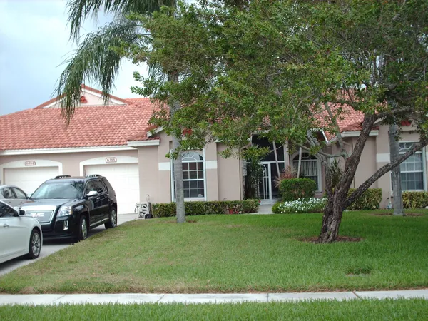 a front view of a house with a garden and trees