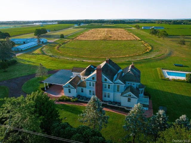 an aerial view of a house with a garden and lake view