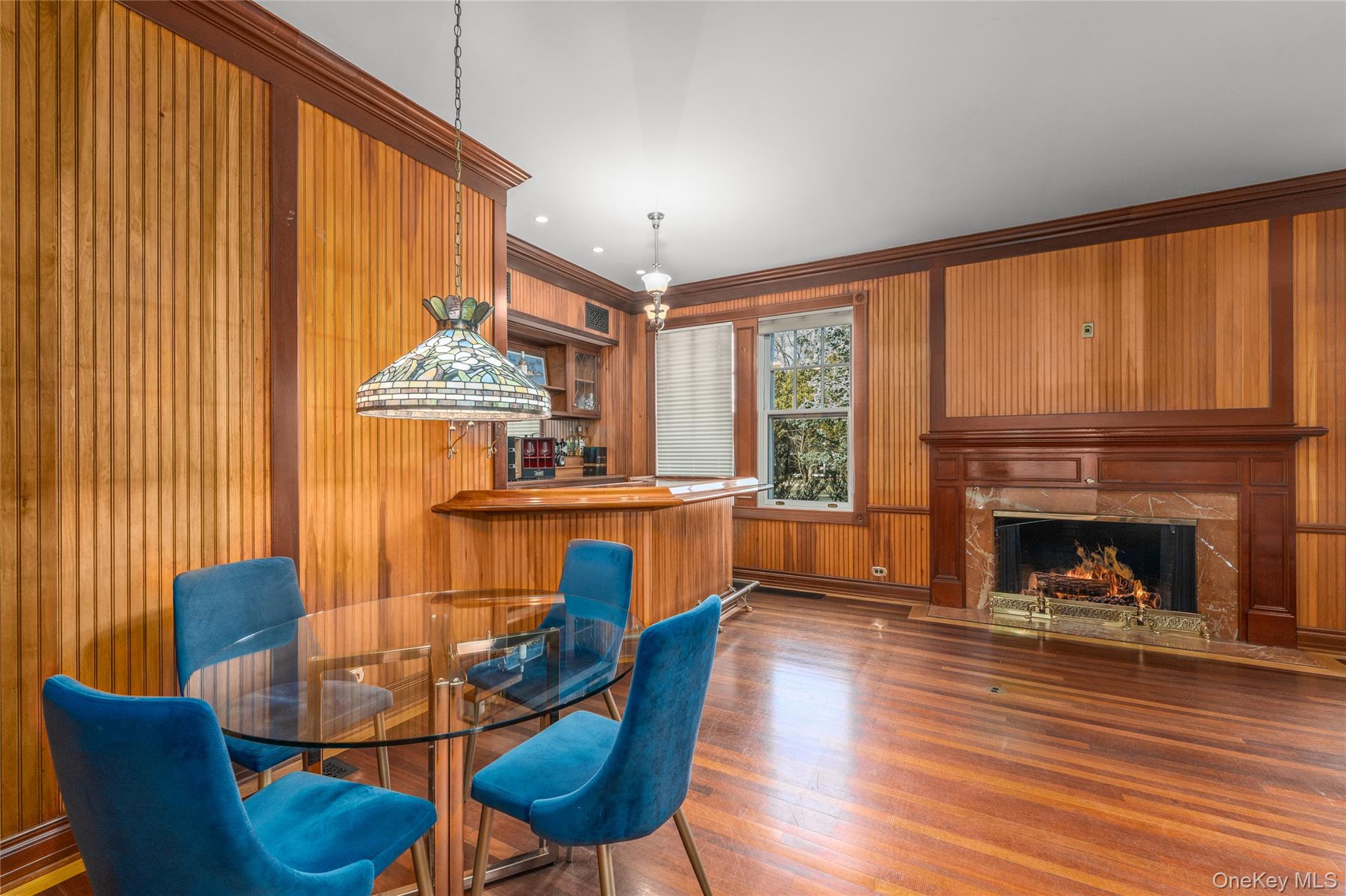 6133 Sound Avenue Riverhead, NY 11901 - Photo 14 of 42 a dining room with furniture a fireplace and wooden floor