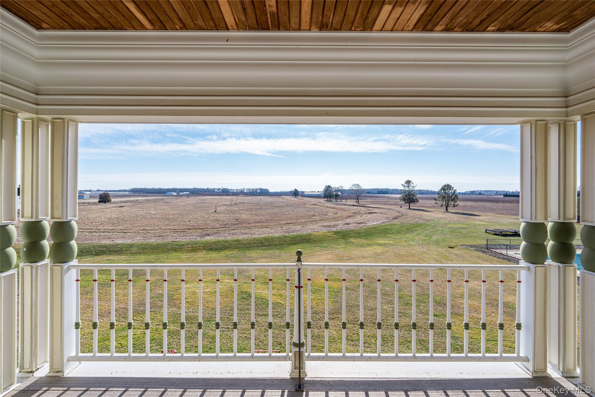 6133 Sound Avenue Riverhead, NY 11901 - Photo 27 of 42 a view of a balcony with floor to ceiling windows and wooden floor