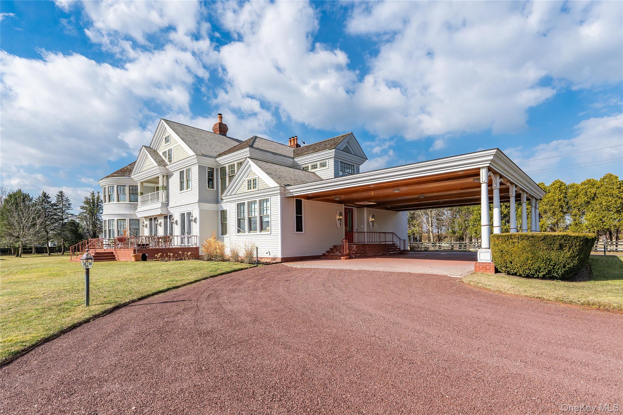 6133 Sound Avenue Riverhead, NY 11901 - Photo 7 of 42 a view of a white house next to a yard with big trees