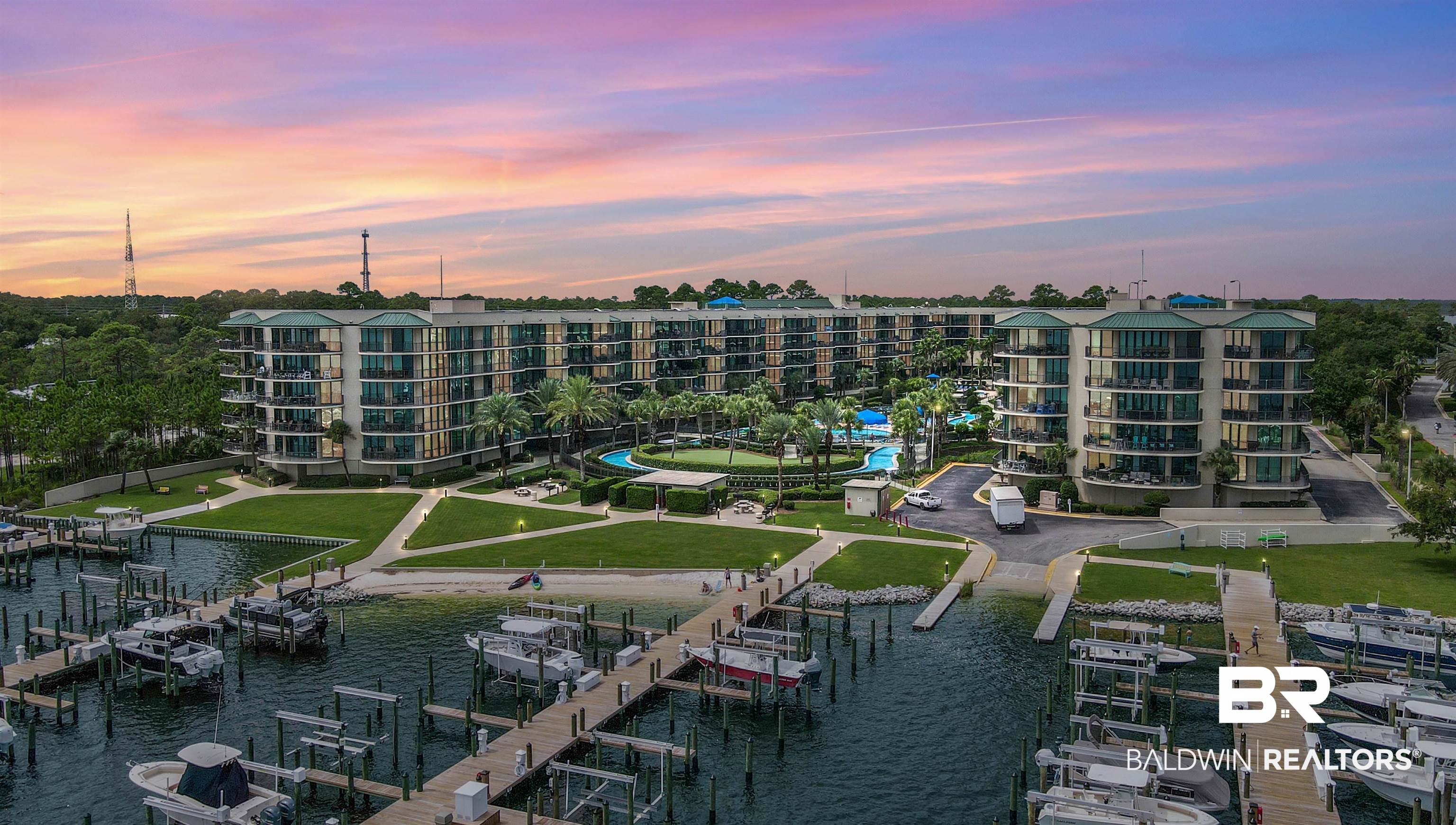 27580 Canal Road, Unit 1421 Orange Beach, AL 36561 - Photo 9 of 40 Waterfront condominium complex featuring multiple buildings with private balconies, a marina with boat slips, an outdoor swimming pool, and manicured green spaces
