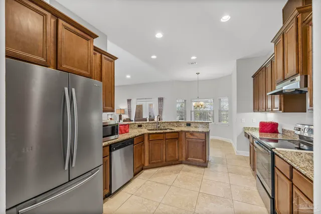 a kitchen with stainless steel appliances granite countertop a refrigerator and a sink