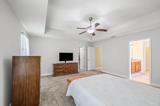 a spacious bedroom with a bed and a flat screen tv