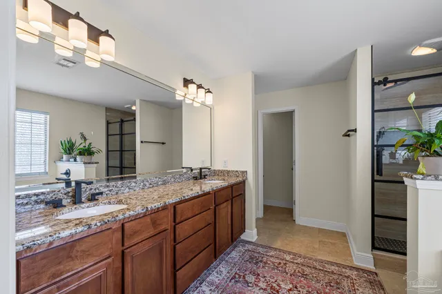 a spacious bathroom with a granite countertop sink and a mirror