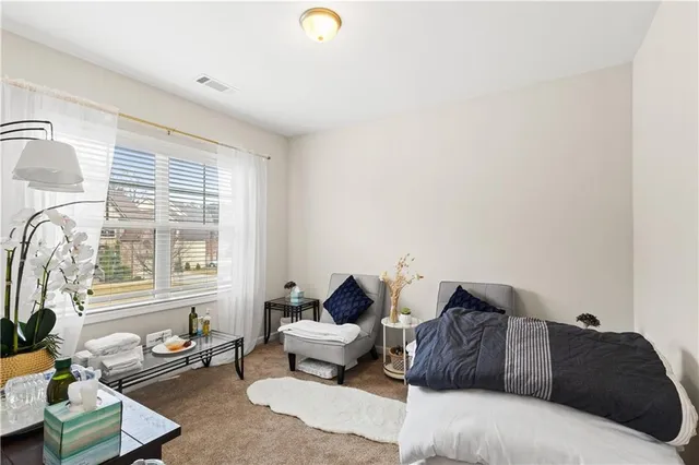 a spacious bedroom with a bed and a chandelier
