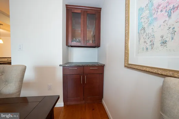 a view of a hallway with wooden floor and cabinet