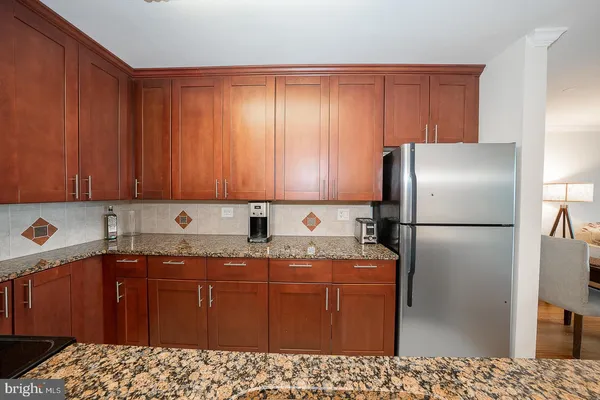 a kitchen with stainless steel appliances granite countertop a refrigerator a sink and dishwasher