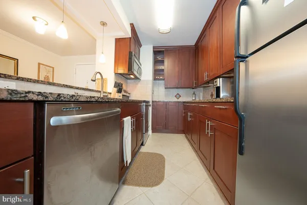 a kitchen with stainless steel appliances granite countertop a sink a stove and a refrigerator