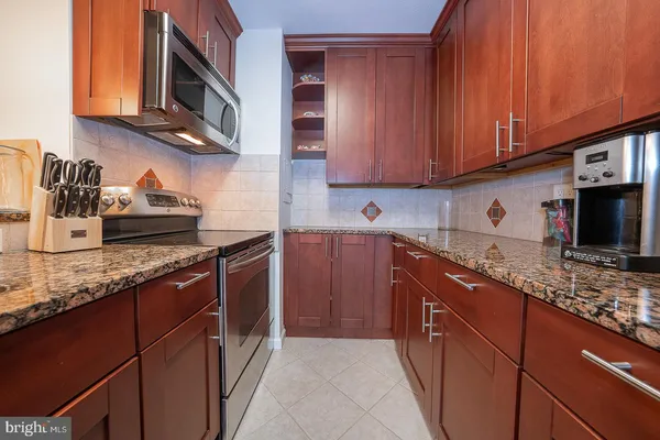 a kitchen with stainless steel appliances granite countertop a sink stove and cabinets