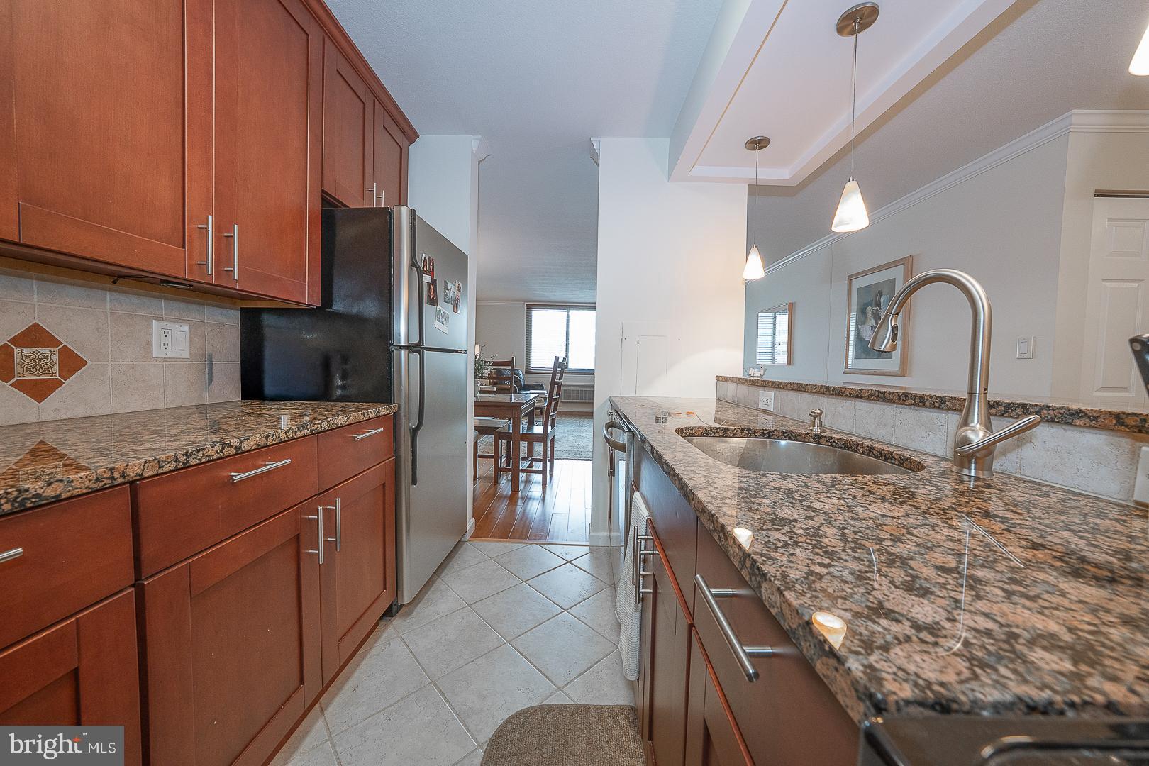 1919 Chestnut Street, Unit 2822 Philadelphia, PA 19103 - Photo 19 of 36 a kitchen with stainless steel appliances granite countertop a sink stove and cabinets