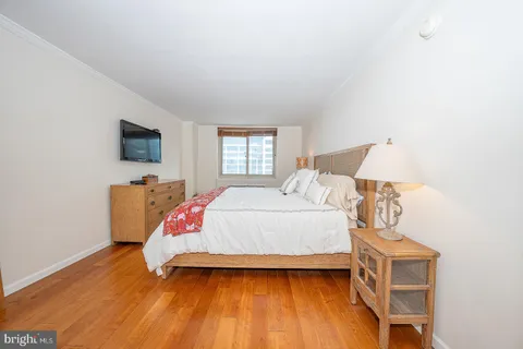 a bedroom with a bed and wooden floor