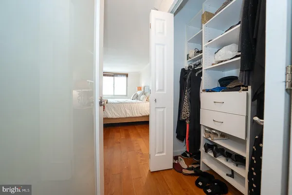 a view of walk in closet with clothes and shoes