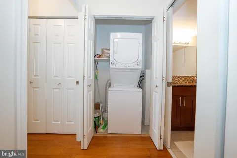 a view of a hallway with wooden floor and closet