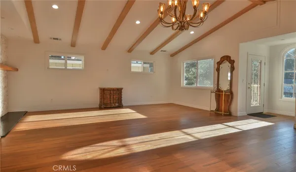 a view of a livingroom with wooden floor and a ceiling fan