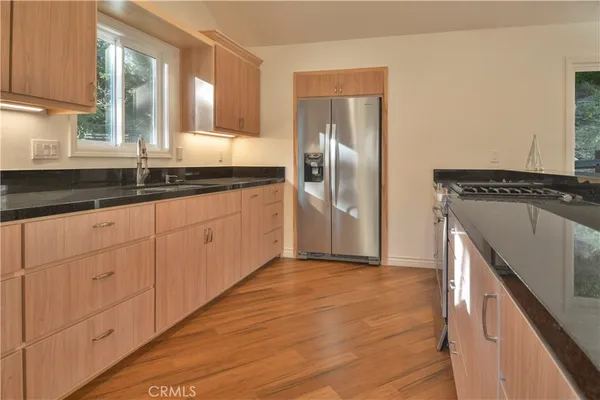 a kitchen with granite countertop a refrigerator and a sink