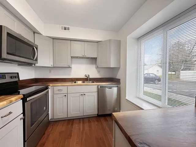 a kitchen with stainless steel appliances granite countertop a stove a sink and a microwave