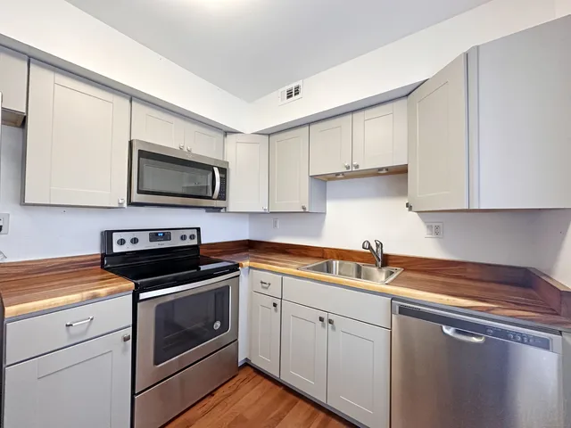 a kitchen with cabinets appliances a sink and a counter top