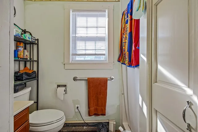 a bathroom with a toilet and a shower curtain
