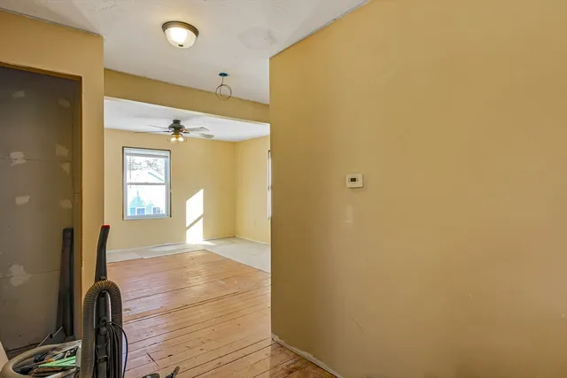 a view of a hallway with wooden floor and staircase