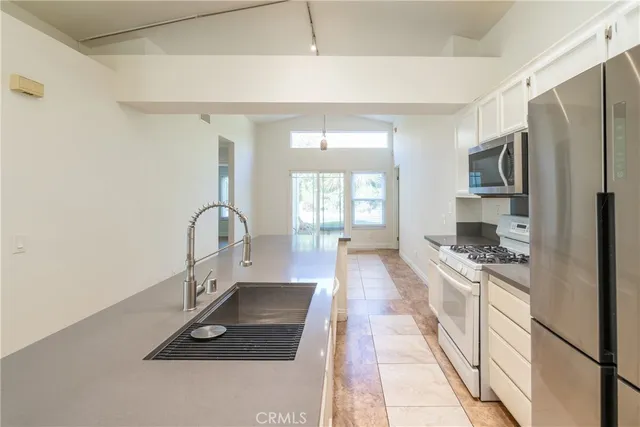 a kitchen with refrigerator a stove and a sink