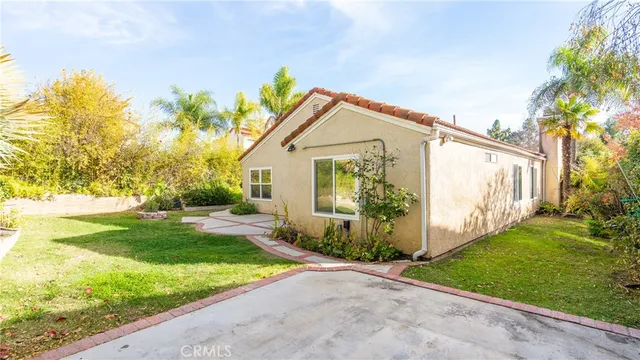 a view of a house with backyard and a tree