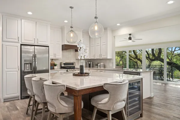 a kitchen with stainless steel appliances granite countertop a kitchen island a stove a table and chairs